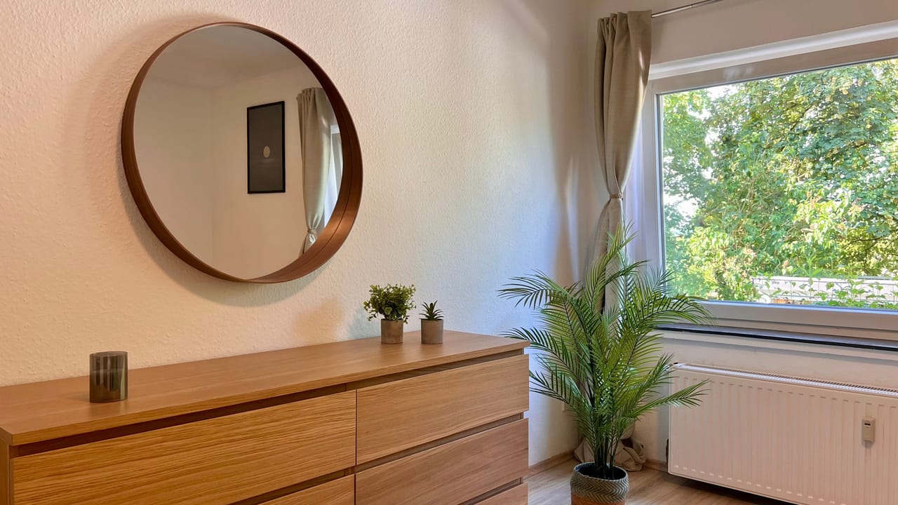 Kommode mit rundem Spiegel im Schlafzimmer