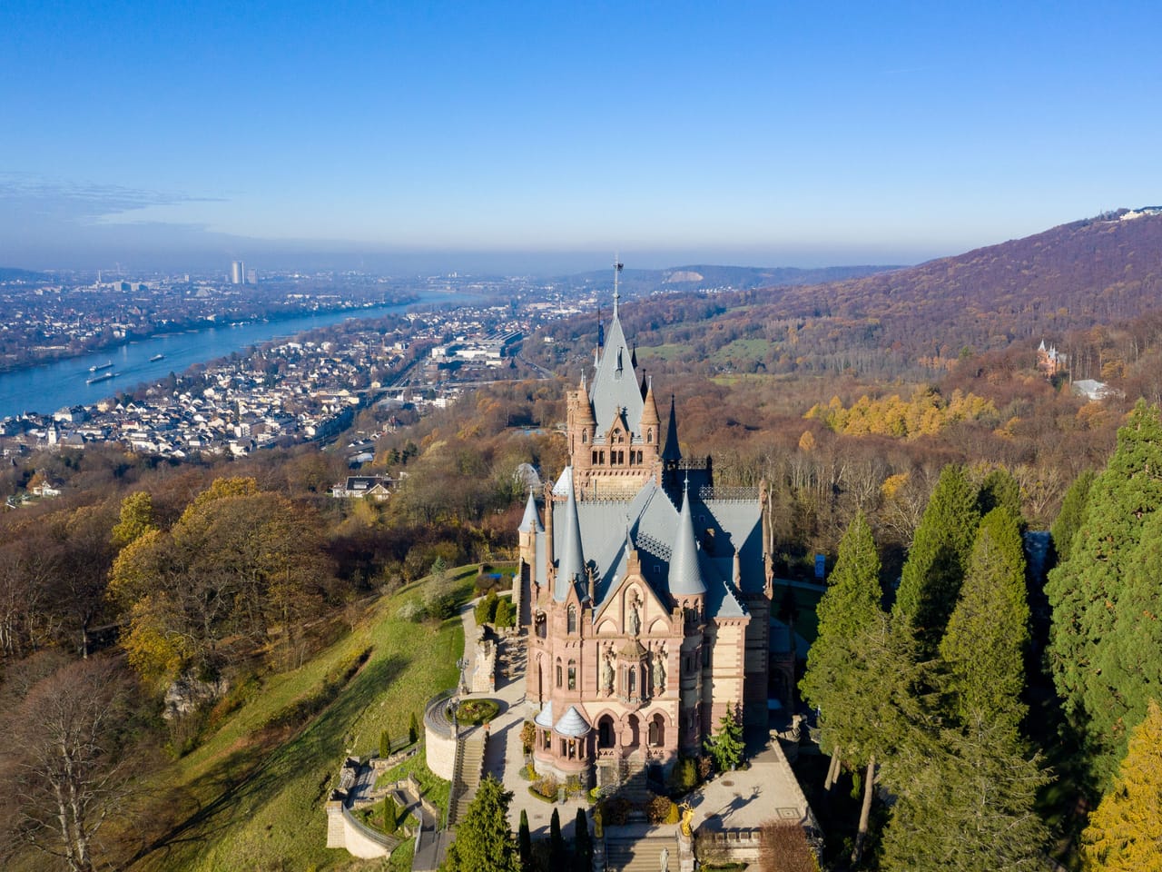 Schloss Drachenburg über dem Rheintal, dahinter der Rhein mit Königswinter und Bonn